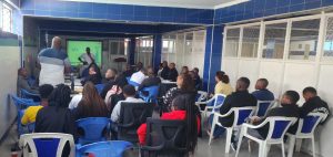 A professional meeting room where an individual ask a question to the speaker, while others attentively listen during a business seminar or conference."